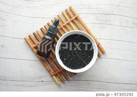 Black sesame in a container with oil in a jar on table. Black sesame in a container with oil in a jar on table. 97305292
