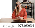 Smiling woman working on laptop 97305934