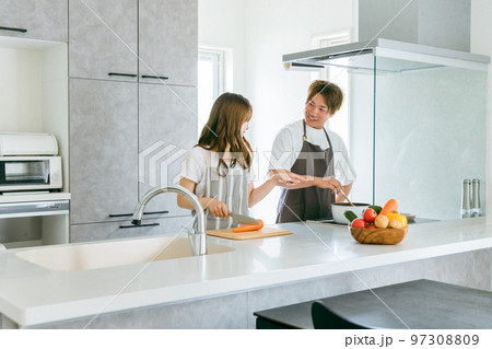 家のキッチンで一緒に料理を作る共働きのアジア人夫婦の男女（料理男子） 97308809