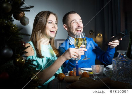 Man and woman watching tv at Christmas night 97310094