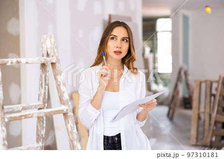Woman construction manager checking project documentation 97310181