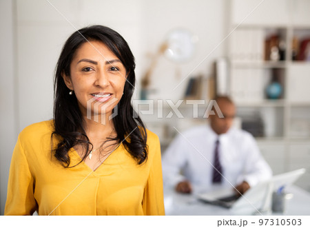 Successful latin american business woman standing in office Successful latin american business woman standing in office 97310503