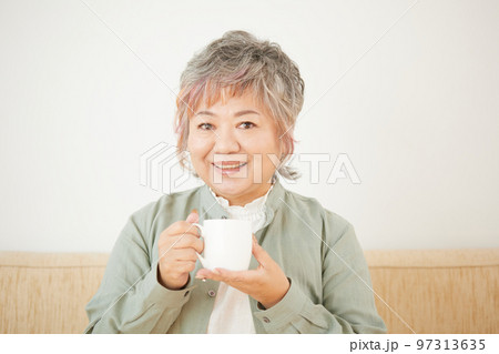 ソファーでお茶を飲むシニア女性 97313635