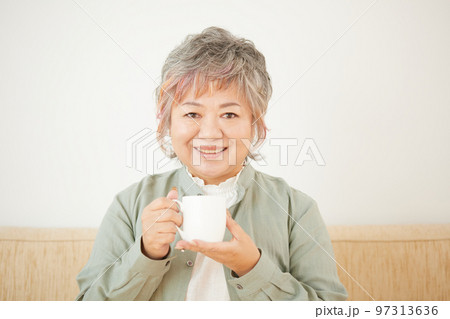 ソファーでお茶を飲むシニア女性 97313636