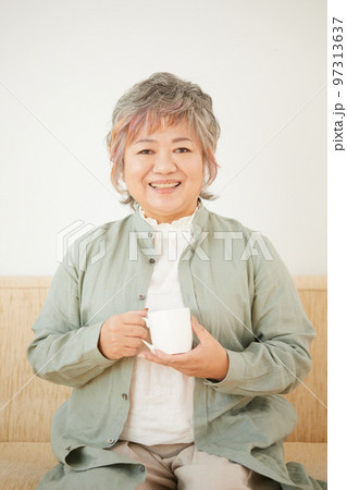 ソファーでお茶を飲むシニア女性 ソファーでお茶を飲むシニア女性 97313637