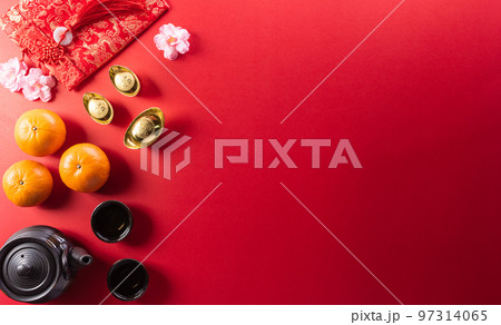 Chinese new year decorations made from red packet, orange and gold ingots or golden lump on a red background. Chinese characters FU in the article refer to fortune good luck, wealth, money flow. 97314065