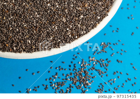 Healthy food, Chia seeds or superfood in white bowl and falling on light blue background 97315435