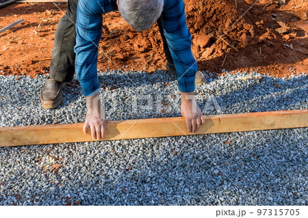 For deck foundation in backyard shed was leveled by placing wood lumber on gravel provide For deck foundation in backyard shed was leveled by placing wood lumber on gravel provide 97315705