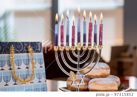 Candles for Hanukkah against on Hanukkiah Menorah blurred backdrop defocused lights 97315852
