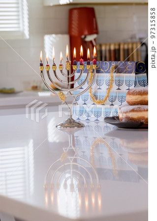 Jewish holiday symbol Hanukkah brightly glowing on Hanukkiah Menorah blurred backdrop 97315858