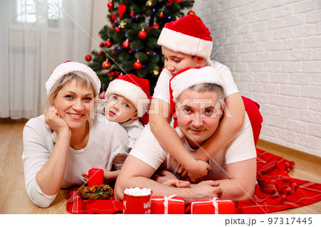 Cheerful parents playing with sons at new home. Family leisure Cheerful parents playing with sons at new home. Family leisure 97317445