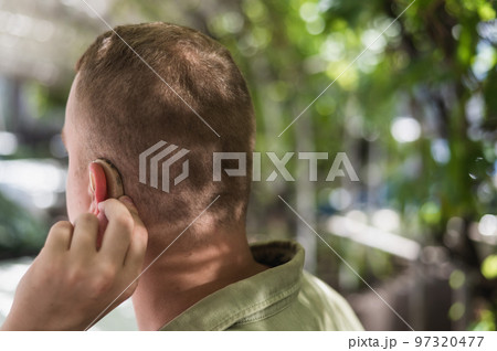 Close-up of a hearing aid on a man's ear. Close-up of a hearing aid on a man's ear. 97320477