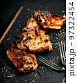 BBQ chicken thighs on a black cutting board. Soft focus. Vertical shot 97322454