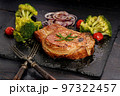 Appetizing BBQ pork loin with vegetables on a black stone board. Roast pork meat and broccoli 97322457