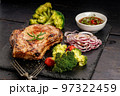 Close-up BBQ pork loin with spicy sauce and vegetables on a black stone board. Selective focus 97322459