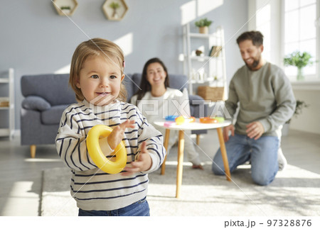Portrait of cute little child girl playing with colorful rainbow toy pyramid details. 97328876
