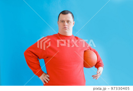 a man with down syndrome on an isolated blue background. 97330405