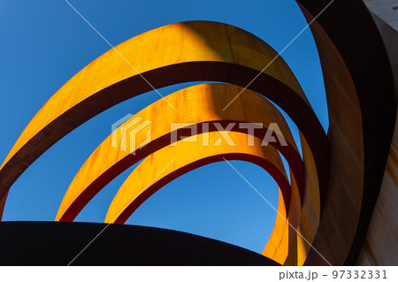 Sunlit unusual building against cloudless sky 97332331