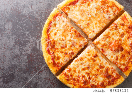 Delicious crispy New York style pizza with melted cheese and base tomato sauce close-up on a wooden board. Horizontal top view Delicious crispy New York style pizza with melted cheese and base tomato sauce close-up on a wooden board. Horizontal top view 97333132