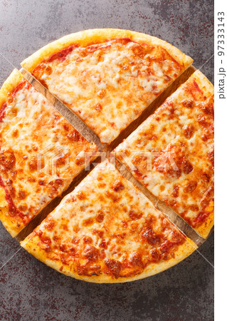 Hot fresh New York Style Pizza with marinara sauce and topped with mozzarella cheese on the board. Vertical top view Hot fresh New York Style Pizza with marinara sauce and topped with mozzarella cheese on the board. Vertical top view 97333143