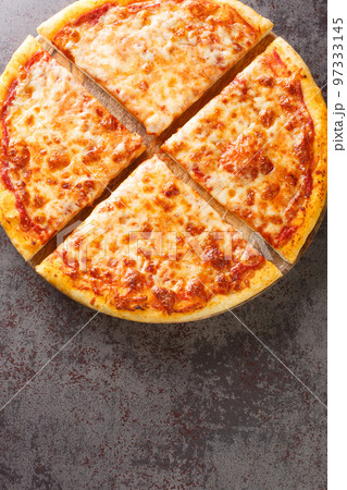 Authentic traditional New York City style pizza pie closeup on the board on the table. Vertical top view Authentic traditional New York City style pizza pie closeup on the board on the table. Vertical top view 97333145