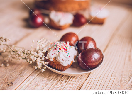 Easter table with traditional Easter cakes and Easter eggs with blossoming tree branch Easter table with traditional Easter cakes and Easter eggs with blossoming tree branch 97333830