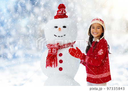Child building snowman. Kids build snow man. Child building snowman. Kids build snow man. 97335843