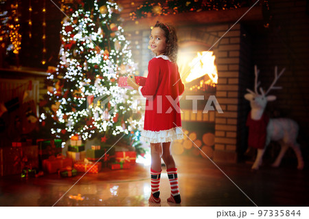 Kids at Christmas tree. Children open presents Kids at Christmas tree. Children open presents 97335844