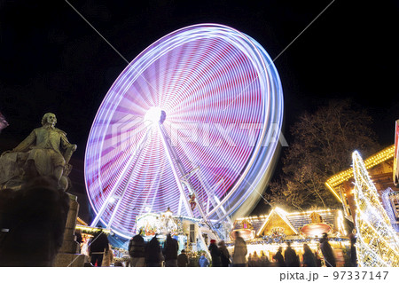 Scenic view of traditional old german Christmas market square in Magdeburg with light decoration illuminated ferris wheel, historical Otto monument and people. Christmas new Year celebration winter Scenic view of traditional old german Christmas market square in Magdeburg with light decoration illuminated ferris wheel, historical Otto monument and people. Christmas new Year celebration winter 97337147