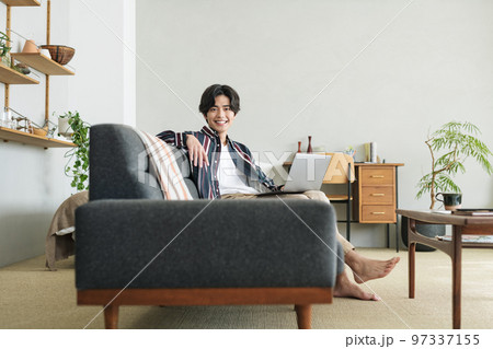 オシャレな部屋で一人暮らしをする若い男性 オシャレな部屋で一人暮らしをする若い男性 97337155