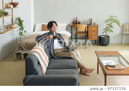 オシャレな部屋で一人暮らしをする若い男性 オシャレな部屋で一人暮らしをする若い男性 97337156