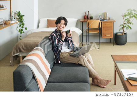 オシャレな部屋で一人暮らしをする若い男性 オシャレな部屋で一人暮らしをする若い男性 97337157