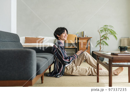 オシャレな部屋でパソコンを使う若い男性 オシャレな部屋でパソコンを使う若い男性 97337235
