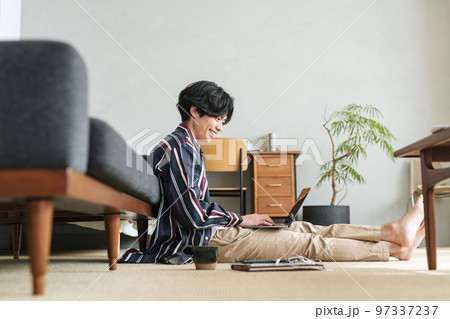 オシャレな部屋でパソコンを使う若い男性 97337237