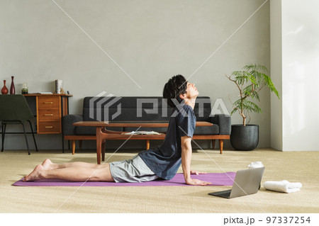 自宅で腰のストレッチをする男性 97337254