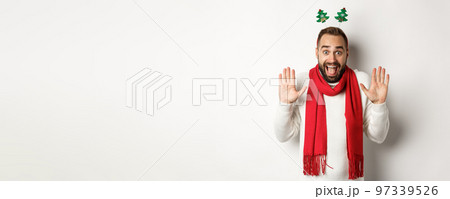 Christmas holidays. Excited bearded man raising hands up and shouting for joy, celebrating New Year party, standing against white background Christmas holidays. Excited bearded man raising hands up and shouting for joy, celebrating New Year party, standing against white background 97339526