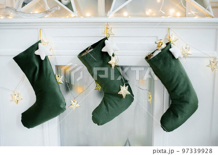 Christmas socks for Santa Claus gifts hang over the fireplace in the house 97339928