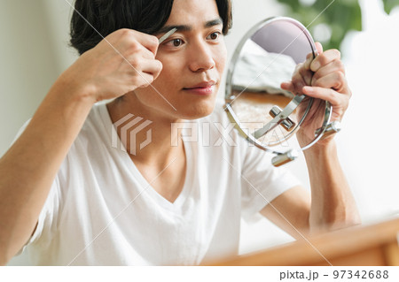 ハサミで眉毛を整える若い男性 97342688