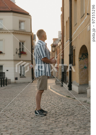 A middle-aged male tourist is looking at the sights in an old European town A middle-aged male tourist is looking at the sights in an old European town 97355296