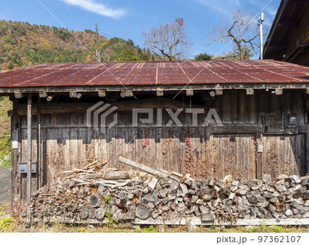 小屋の前に積まれた薪 97362107