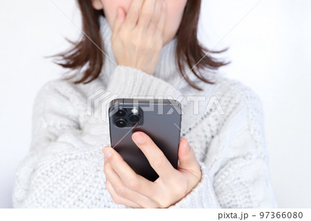 スマホを見て驚く女性 スマホを見て驚く女性 97366080