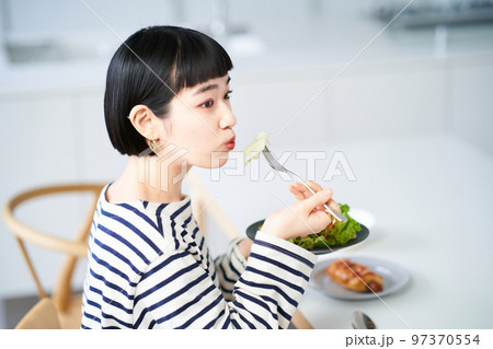 家のダイニングで食事をする女性 家のダイニングで食事をする女性 97370554