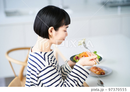 家のダイニングで食事をする女性 家のダイニングで食事をする女性 97370555