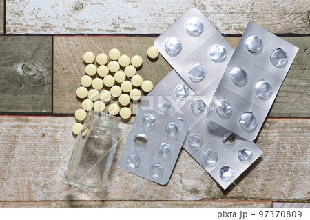 散らばる錠剤と薬の包装シート 97370809