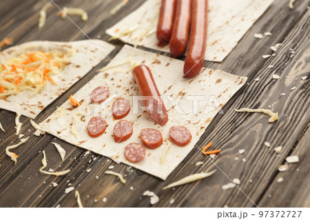 sausages, pickled cabbage and pita bread on wooden background 97372727