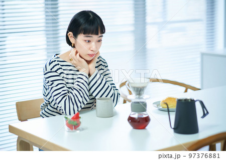部屋でコーヒーを飲む若い女性 部屋でコーヒーを飲む若い女性 97376881