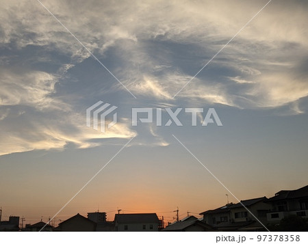 シルエットの町並みの夕焼け空と白い雲 97378358