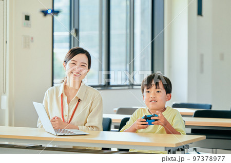 ドローンを操作する小学生の男の子 97378977