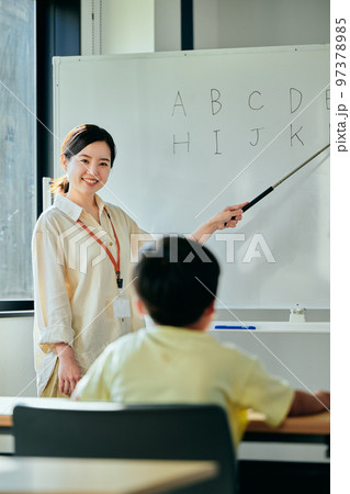 英会話教室で英語を教える若い塾講師 97378985
