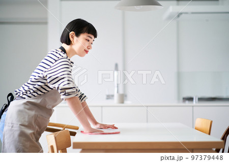 ダイニングテーブルを拭く若い女性 ダイニングテーブルを拭く若い女性 97379448